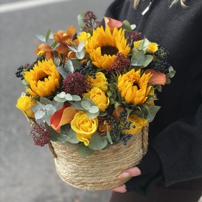 Композиция в сумке "Тональность" из подсолнухов, калл, ягод вибирнума, лимонных роз, скиммии и орхидеи в Наро-Фоминске
